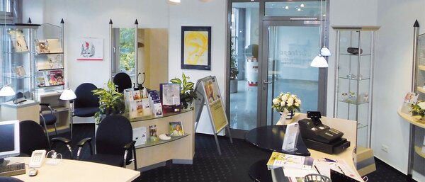 Modernes, helles Büro mit Empfangsbereich, Beratungstischen und Infomaterialien.